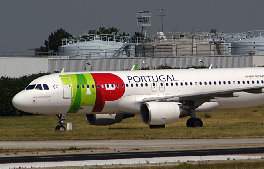 Un avion de ligne aux couleurs de TAP stationné sur une piste.