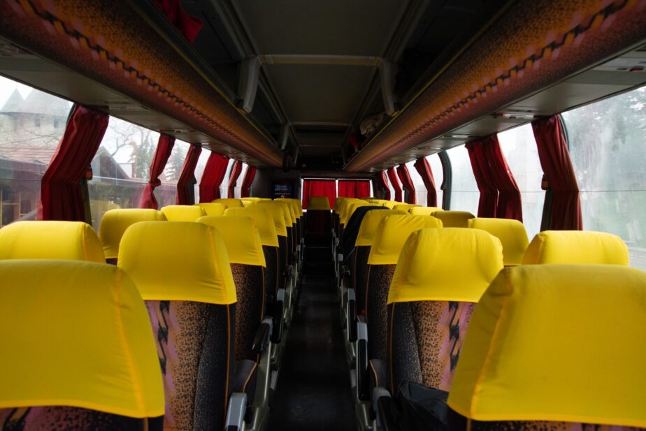 Intérieur d’un autocar avec des rangées de sièges jaunes.