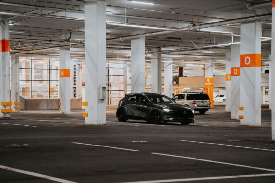 Voitures stationnées dans un parking intérieur sous un immeuble.