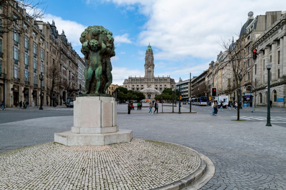 Vue de l’avenue des Aliados, avec une sculpture au premier plan et un grand bâtiment au fond.