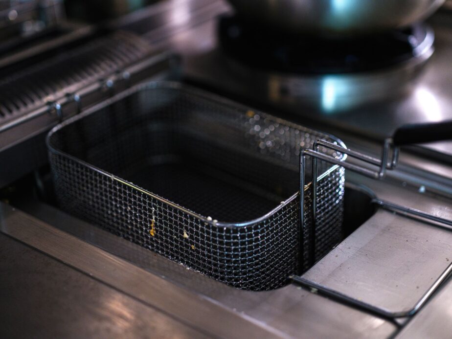 Une friteuse vide dans une cuisine professionnelle en inox.